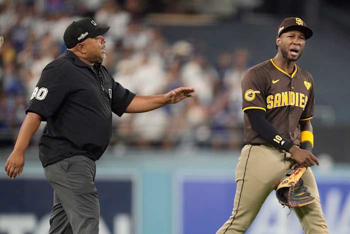San Diego Padres linksvelder Jurickson Profar, rechts, praat met scheidsrechter Adrian Johnson nadat er items naar Profar in het outfield zijn gegooid tijdens de zevende inning in Game 2 van een honkbal NL Division Series tegen de Los Angeles Dodgers, zondag 6 oktober 2024 , in Los Angeles. (AP-foto/Ashley Landis)
