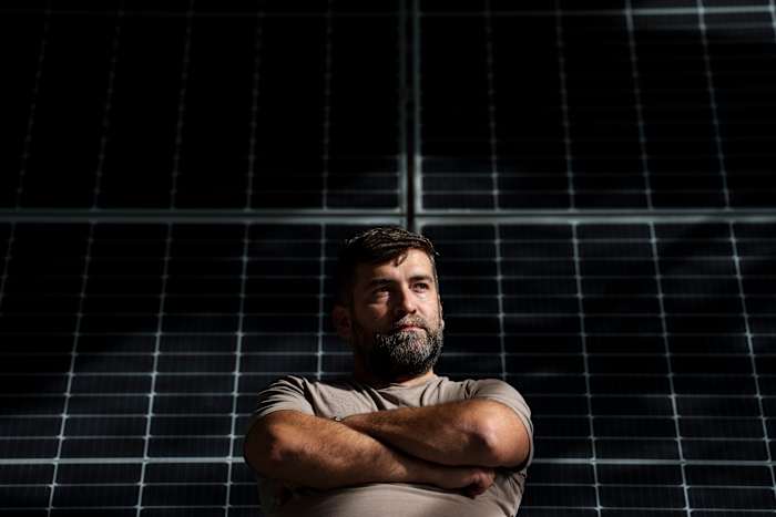 Sebastian Tirintica zit op de achtergrond van zonnepanelen in het RenewAcad-trainingscentrum in Petrosani, Zuid-Roemenië, vrijdag 11 oktober 2024. (AP Photo/Vadim Ghirda)