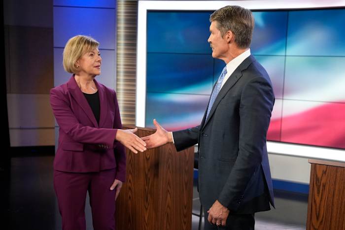 Senaatskandidaten uit Wisconsin, de Republikein Eric Hovde en de Democratische Amerikaanse senator Tammy Baldwin schudden elkaar de hand voor een televisiedebat op vrijdag 18 oktober 2024 in Madison, Wisconsin. (AP Photo/Morry Gash)