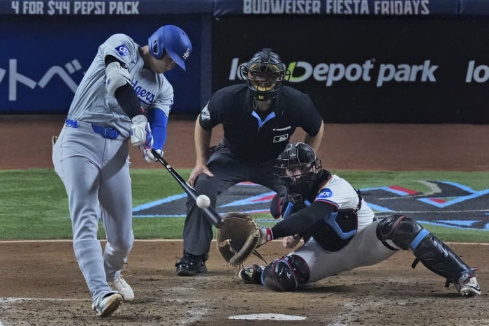 Shohei Ohtani uit Los Angeles Dodgers uit Japan slaat een homerun en scoort Hunter Feduccia tijdens de derde inning van een honkbalwedstrijd tegen de Miami Marlins, dinsdag 17 september 2024, in Miami. (AP-foto/Wilfredo Lee)