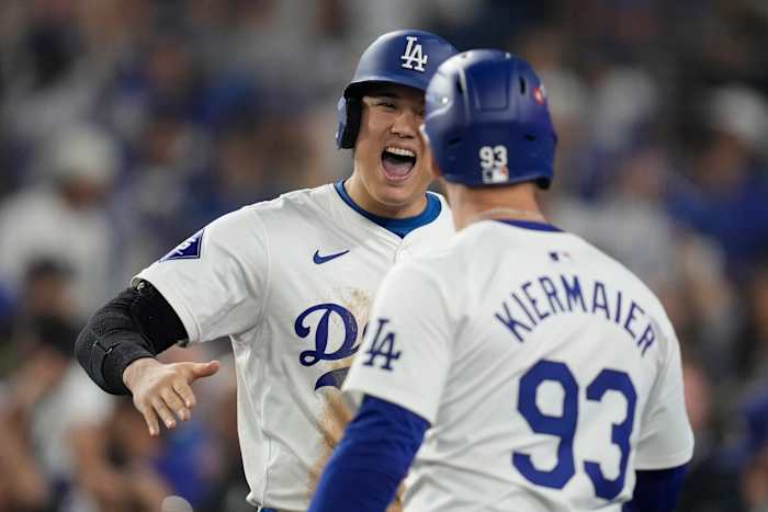Shohei Ohtani van Los Angeles Dodgers viert feest met Kevin Kiermaier (93) na te hebben gescoord op een tweehonkslag van Mookie Betts tijdens de achtste inning in Game 1 van een honkbal NL Championship Series tegen de New York Mets, zondag 13 oktober 2024, in Los Angeles Angeles. (AP-foto/Ashley Landis)
