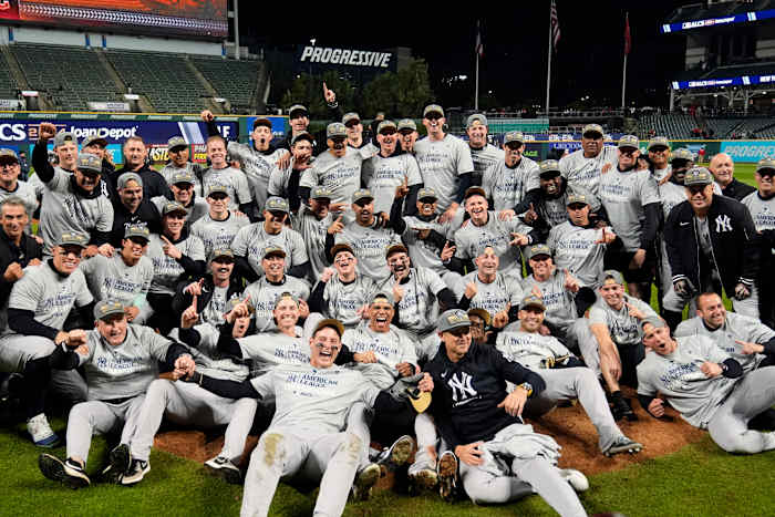 Spelers van de New York Yankees poseren voor een teamfoto na Game 5 van de honkbal AL Championship Series tegen de Cleveland Guardians zaterdag 19 oktober 2024 in Cleveland. De Yankees wonnen met 5-2 om door te gaan naar de World Series. (AP Foto/Sue Ogrocki)