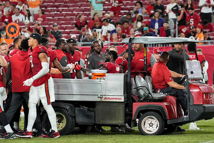 Tampa Bay Buccaneers brede ontvanger Chris Godwin (14) heeft interactie met zijn teamgenoten terwijl hij van het veld wordt afgevoerd na een blessure tijdens de tweede helft van een NFL-voetbalwedstrijd tegen de Baltimore Ravens, maandag 21 oktober 2024, in Tampa, Florida (AP Foto/Chris O'Meara)