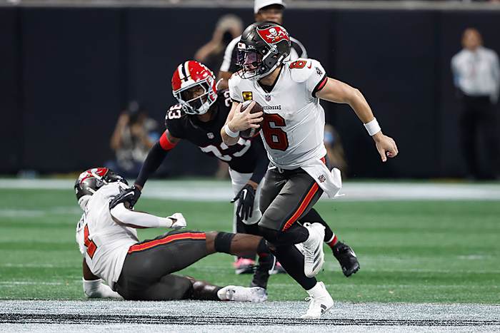 Tampa Bay Buccaneers quarterback Baker Mayfield (6) rent weg van Atlanta Falcons cornerback Antonio Hamilton Sr. (33) tijdens de tweede helft van een NFL-voetbalwedstrijd op donderdag 3 oktober 2024 in Atlanta. (AP Foto/Butch Dille)