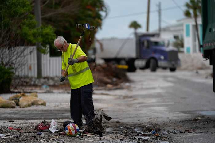 Teams werken aan het opruimen van stapels puin van de overstroming van orkaan Helene voorafgaand aan de aankomst van orkaan Milton, in Holmes Beach op Anna Maria Island, Florida, dinsdag 8 oktober 2024. (AP Photo/Rebecca Blackwell)