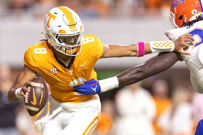 Tennessee quarterback Nico Iamaleava (8) probeert te ontsnappen uit de greep van Kamran James (24), de rand van Florida, tijdens de eerste helft van een NCAA college football-wedstrijd, zaterdag 12 oktober 2024, in Knoxville, Tennessee. (AP Photo/Wade Payne )