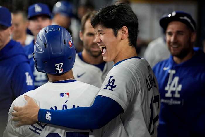 Teoscar Hernndez van Los Angeles Dodgers, links, viert zijn solo-homerun in de dug-out met Shohei Ohtani tijdens de zevende inning in Game 5 van een honkbal NL Division Series tegen de San Diego Padres, vrijdag 11 oktober 2024, in Los Angeles . (AP-foto/Ashley Landis)