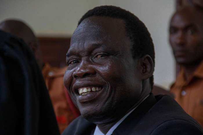 Voormalig commandant van de rebel van het Lord's Resistance Army, Thomas Kwoyelo, glimlacht terwijl hij luistert naar de uitspraak van de rechtbank in Gulu, Oeganda, vrijdag 25 september 2024. (AP Photo)