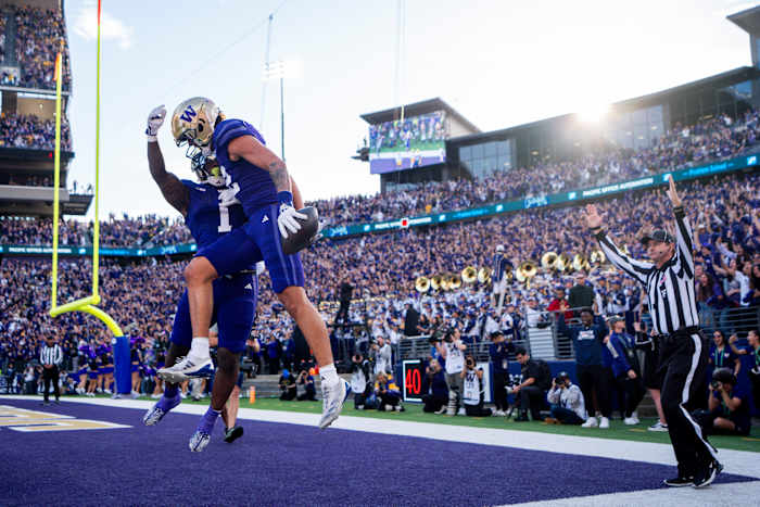 Washington wide receiver Denzel Boston, vooraan, viert zijn touchdown met running back Jonah Coleman (1) tijdens de eerste helft van een NCAA college football-wedstrijd tegen Michigan, zaterdag 5 oktober 2024, in Seattle. (AP-foto/Lindsey Wasson)