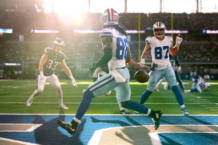 CeeDee Lamb gooit schaduw nadat hij de bal in de zon heeft verloren terwijl Jerry Jones over gordijnen heen kronkelt