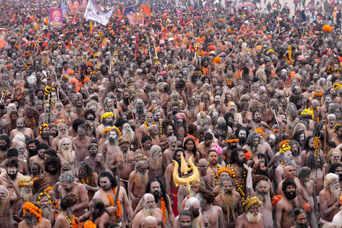 Naakte, met as besmeurde hindoe-asceten nemen een heilige duik op het Maha Kumbh-festival