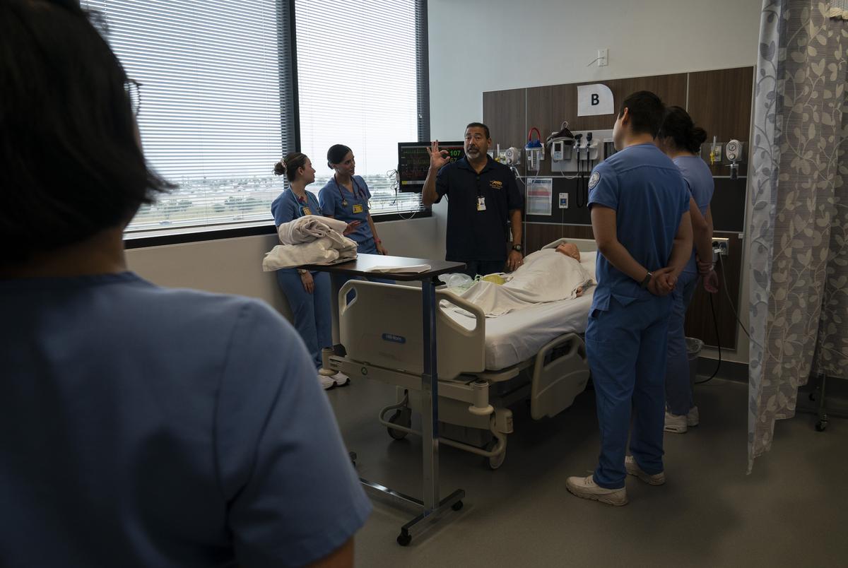 Victor Garza III, MSN, RN en instructeur bij STC gaan over belangrijke punten met betrekking tot de inbeslagname waaraan de studenten werkten in het Simulating Hospital aan het South Texas College in McAllen, Texas op 6 december 2024.Gabriel V. Cárdenas voor de Texas Tribune