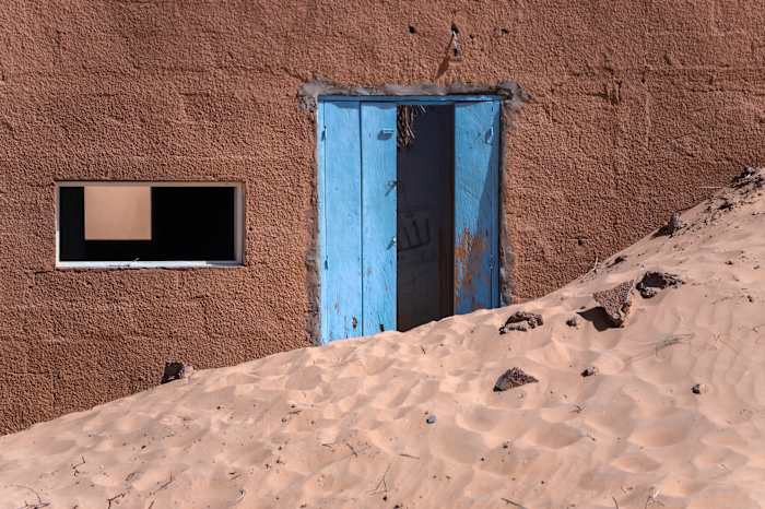 Een binnendringende woestijn dreigt huizen en geschiedenis in te slikken