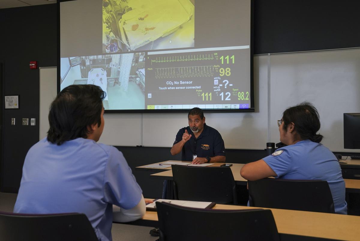Victor Garza III, MSN, RN en instructeur bij STC gaan over de aantekeningen met studenten die verband houden met de simulerende situatie waarin een kind aanvallen had in het Simulating Hospital aan het South Texas College in McAllen, Texas op 6 december 2024.Gabriel V. Cárdenas voor de Texas Tribune