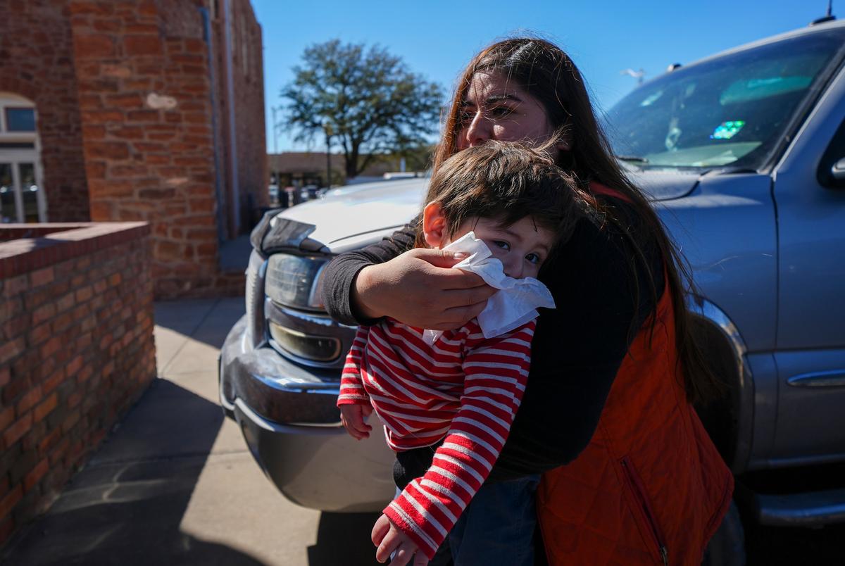 Jennifer Sanchez veegt het gezicht van haar 1-jarige zoon Saul Escamilla af na een vaccin op de Ector County Health Department, maandag 24 februari 2025, in Odessa, Texas.