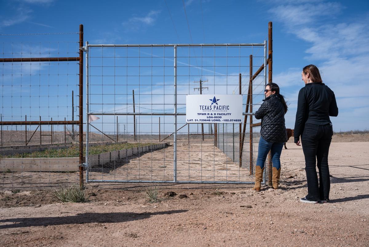 Technical Research & Development Manager Adrianne Lopez, links, en chemicus/bioloog Danielle Smith openen de poort voor een tuinpatch die alfalfa groeit met behandeld geproduceerd water op de Texas Pacific Water Resources Research and Development Project Site op vrijdag 14 februari 2025, buiten Midland.