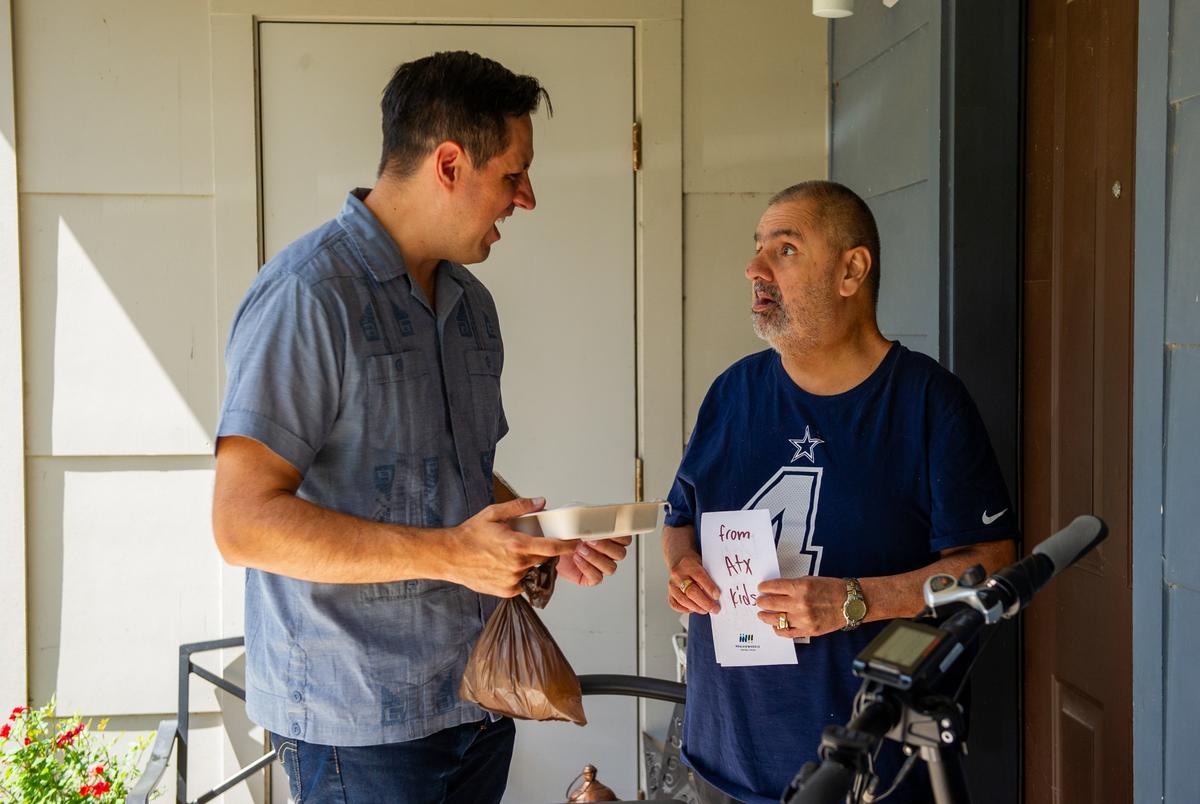 Henry Van de Putte, CEO van maaltijden op wielen Central Austin spreekt tot Austin -inwoner John Albert Rodriguez tijdens een maaltijden op wielen op woensdag in Austin, Texas woensdag 18 juni 2025.