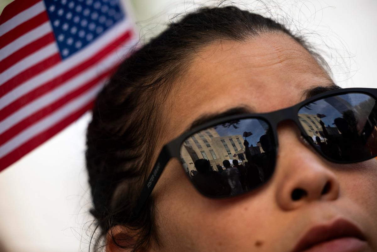 Het stadhuis en demonstranten worden weerspiegeld in de bril van Cristina Medina tijdens een protest No Kings in het stadhuis, zaterdag 14 juni 2025 in Houston. (Antranik Tavitian voor de Texas Tribune)