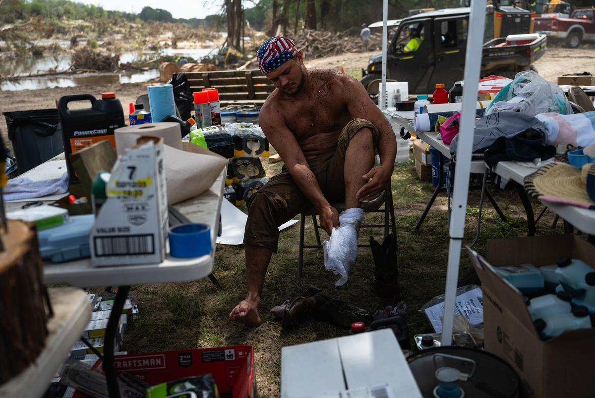 Wyatt Melton, een vrijwilliger uit Buda, verandert zijn doorzochte sokken terwijl hij helpt bij het opruimen en herstelinspanningen in Camp Camp, een zomerkamp voor mensen met een handicap georganiseerd door Children's Association for Maximum Potential, na de Kerr County Flood op vrijdag 11 juli 2025, in Center Point. Cord Shiflet, een collega -vrijwilliger, plaatste een bericht op Facebook waarin vrijwilligers werden opgeroepen om het rivierfront van het kamp schoon te maken en sinds het is gepubliceerd, hebben meer dan 1.000 vrijwilligers hun tijd en middelen aangeboden.