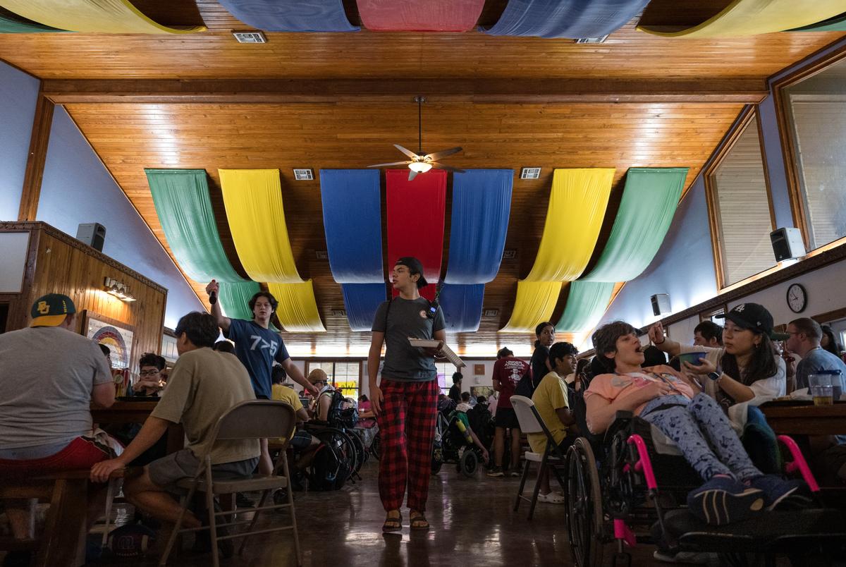 Kampeerders en counselors gaan zitten voor het ontbijt in Camp Camp, een zomerkamp georganiseerd door Children's Association voor maximaal potentieel voor mensen met een handicap, op dinsdag 22 juli 2025, in Center Point.