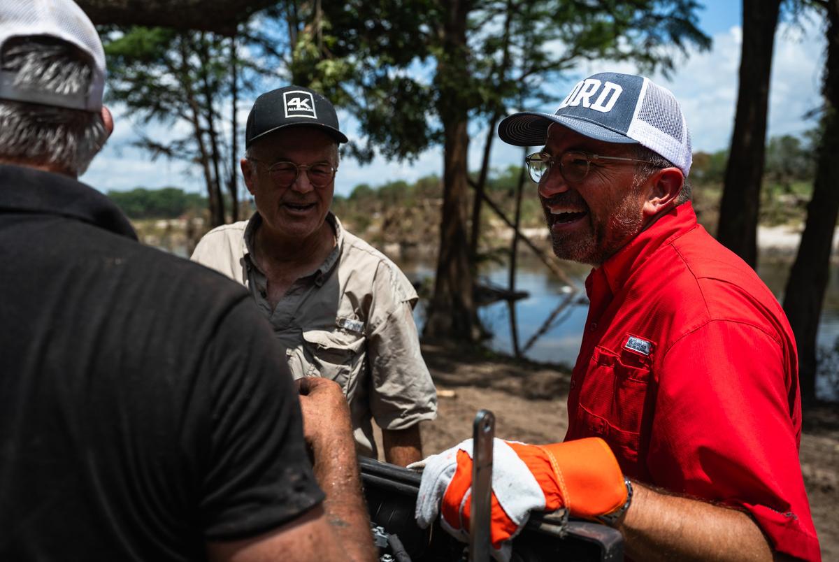 Cord Shiflet, rechts, grappen met vrijwilligers tijdens het helpen bij het opruimen en herstelinspanningen in Camp Camp, een zomerkamp voor mensen met een handicap door Children's Association voor maximaal potentieel, na de Kerr County Flood op vrijdag 11 juli 2025, in Center Point.