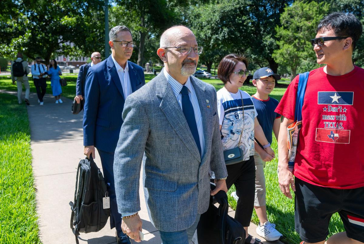 Texas Democraten Jon Rosenthal, D-Houston en Rafael Anchia, D-Dallas, L, stappen uit een charterbus vanaf de luchthaven Austin buiten het State Archives Building aan de oostkant van het Texas Capitol bij hun terugkeer naar Austin na een quorum pauze van twee weken. Rechts van de mens is niet geïdentificeerd.