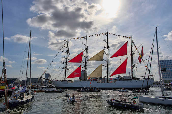 Honderden historische lange schepen varen Amsterdam binnen voor een maritiem festival