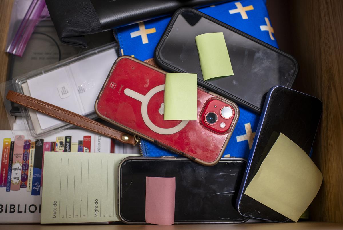 Telefoons die werden genomen van studenten in het bureau van assistent -directeur Dusty Kinslow op Lago Vista High School op dinsdag 9 september 2025 in Lago Vista, TX. HB 1481 is aangenomen tijdens de speciale wetgevende sessie, waarbij scholen een beleid moeten implementeren dat persoonlijke communicatie -apparaten verbiedt. Lago Vista heeft een beleid geïmplementeerd waarbij studenten apparaten opslaan, voornamelijk mobiele telefoons, in magnetisch vergrendelde zakjes die ook de mobiele telefoonservice blokkeren, de apparaten kunnen worden ontgrendeld in het geval van noodsituatie en wanneer de studenten het gebouw verlaten met behulp van een wandgemonteerde sleutel bij de ingang van het gebouw. (Sergio Flores voor de Texas Tribune)