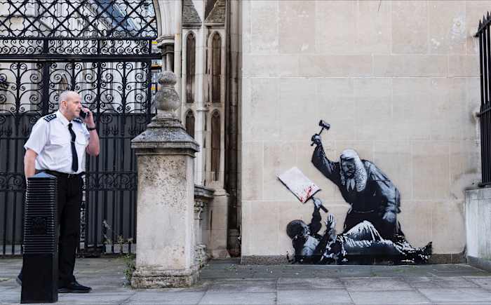 Nieuwe Banksy -muurschildering van een rechter die een demonstrant verslaat om van buiten de rechtbank van Londen te worden verwijderd