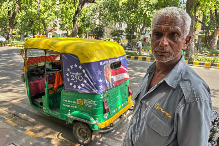 Het portret van Trump raakt het verkeer in New Delhi terwijl de Amerikaanse ambassade 'Happy Birthday America!' uitrolt. riksja's