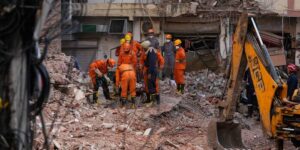 Reddingswerkers zoeken naar overlevenden na de ineenstorting van een hostel in New Delhi waarbij zeven mensen omkomen