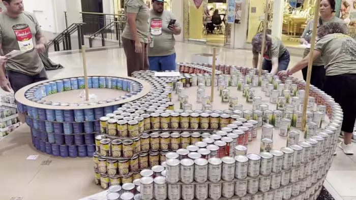 Teams uit San Antonio bouwen gigantische sculpturen uit ongeveer 30.000 blikken om de honger in North Star Mall te bestrijden