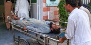 Gewapende mannen richten zich op een ambulance in Pakistan na een zelfmoordaanslag bij een controlepost waarbij twaalf doden vielen