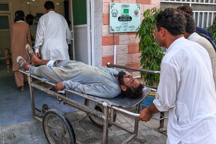 Gewapende mannen richten zich op een ambulance in Pakistan na een zelfmoordaanslag bij een controlepost waarbij twaalf doden vielen